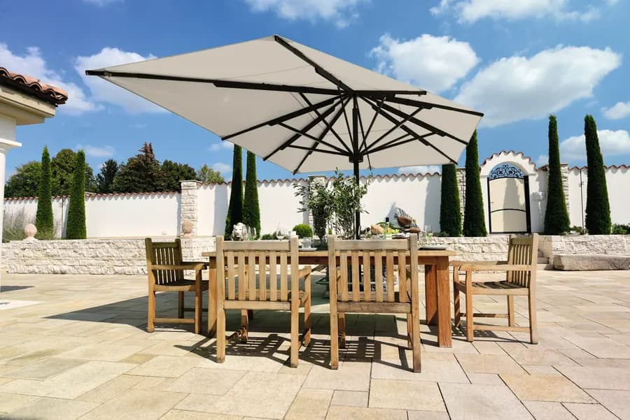 Großschirm über einem Esstisch auf einer gepflasterten Terrasse