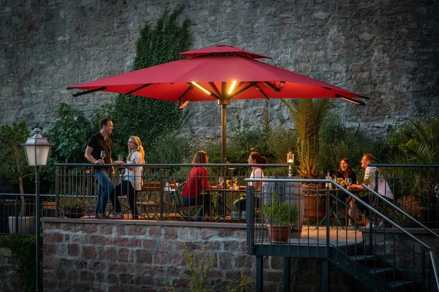 Mittelstockschirm mit zentralem Mast auf einer Terrasse