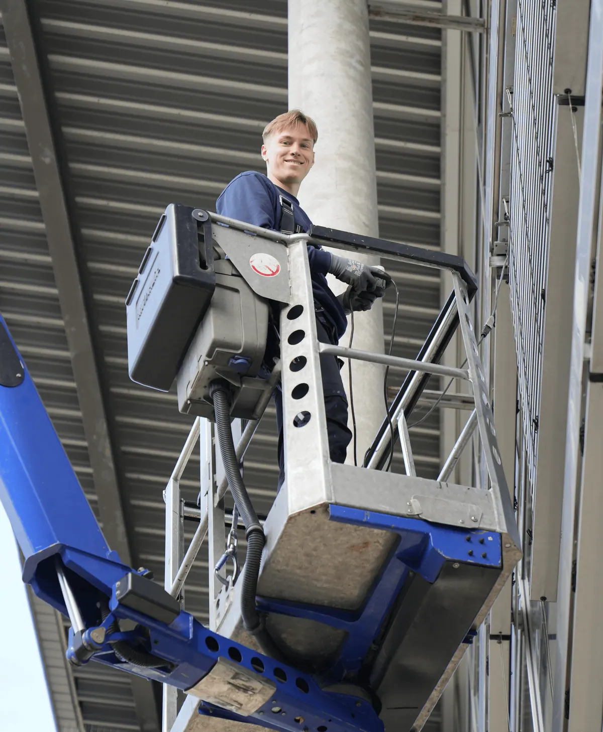 Robert Rother, Azubi bei Westerwalbesloh, auf der Hebebühne bei einer Montage an der Fassade